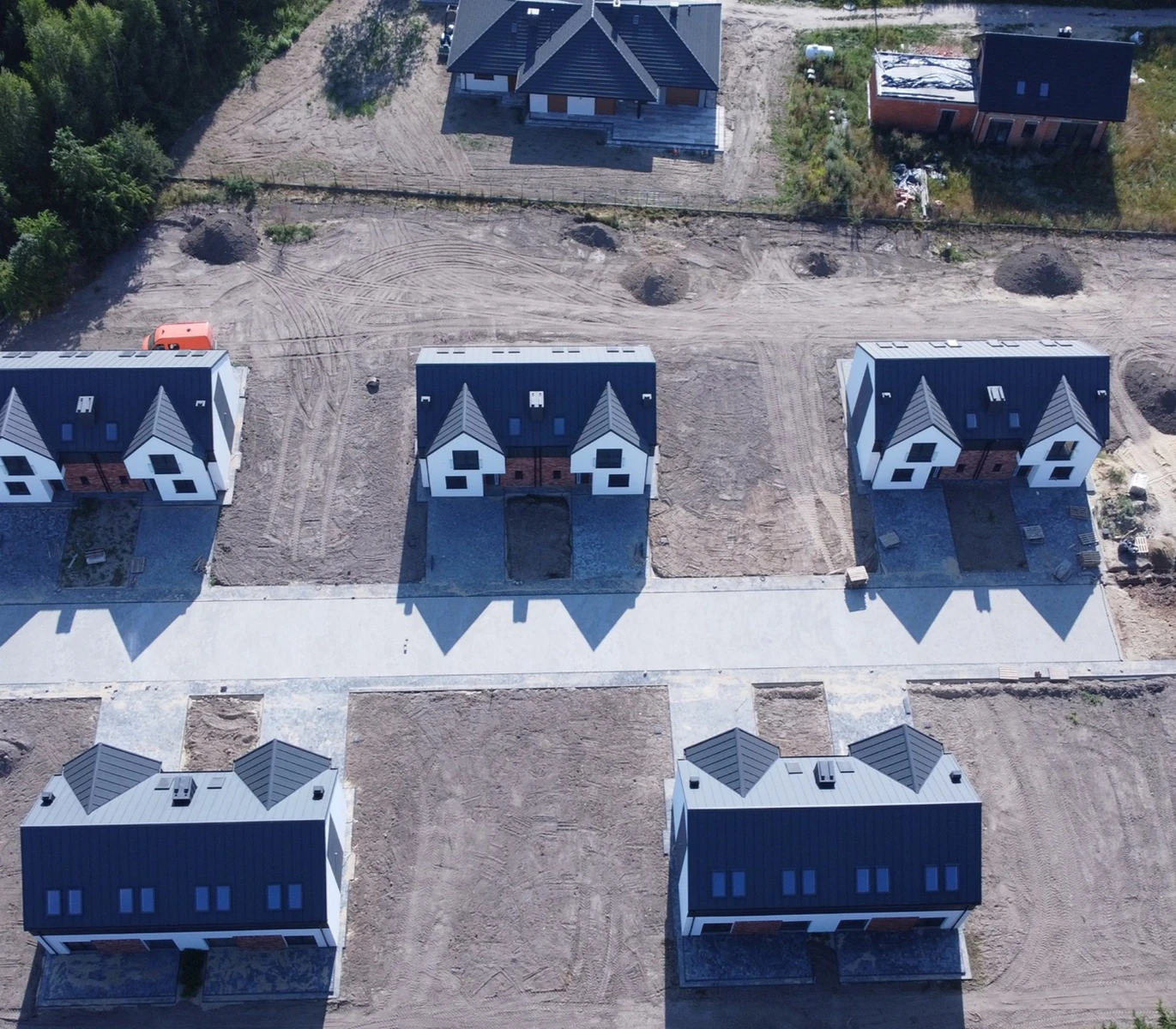 Z lotu ptaka osiedle z wyrównanym terenem i wykonanymi Chodnikami z płyt betonowych